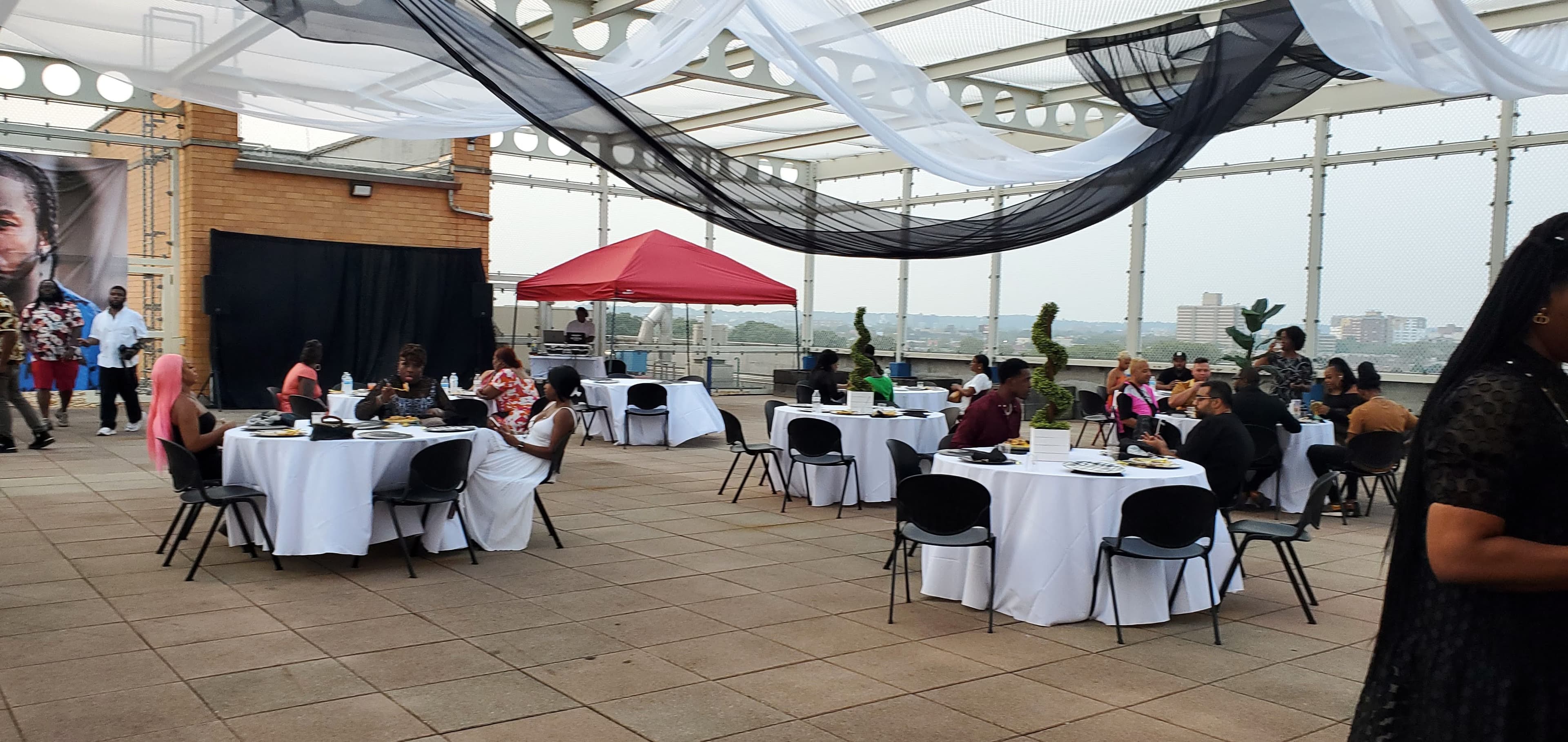 Rooftop reception under draped beams with city skyline views