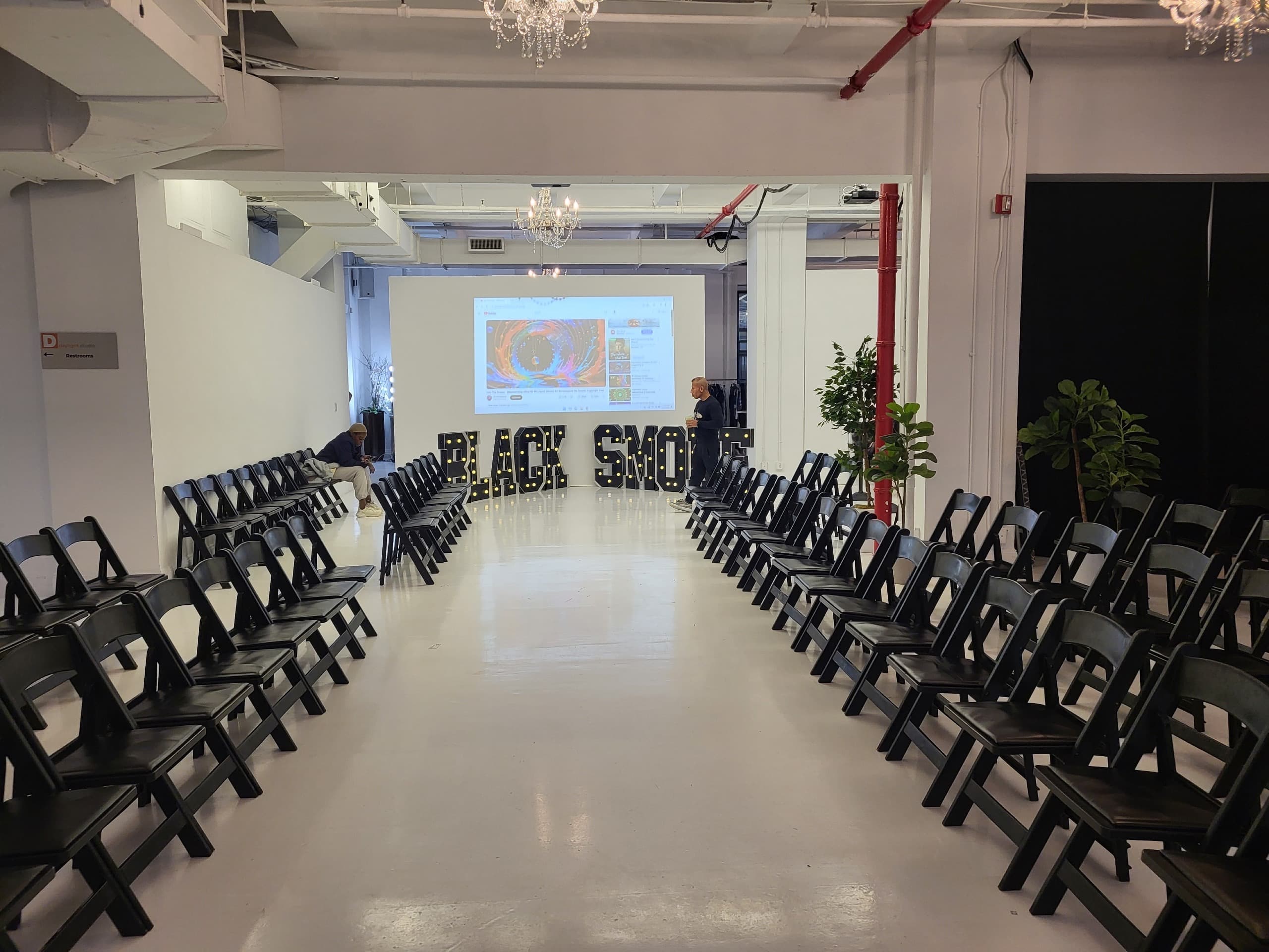 Event aisle, seating, projection, and marquee staging prepared for a program