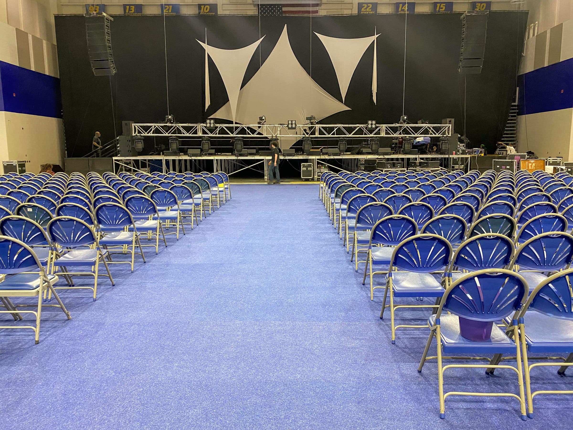 Large-scale stage production with a lighting truss and theater seating
